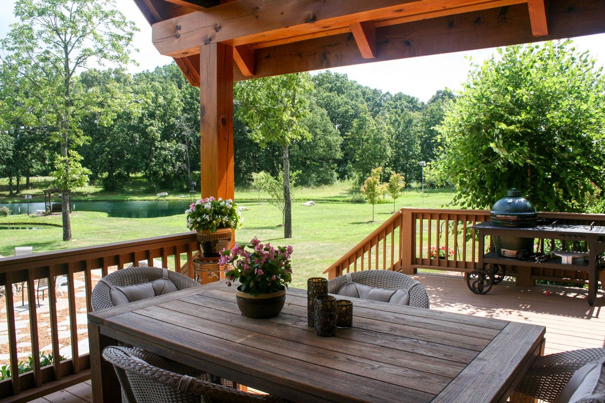 picnic table under roof of deck on cabin