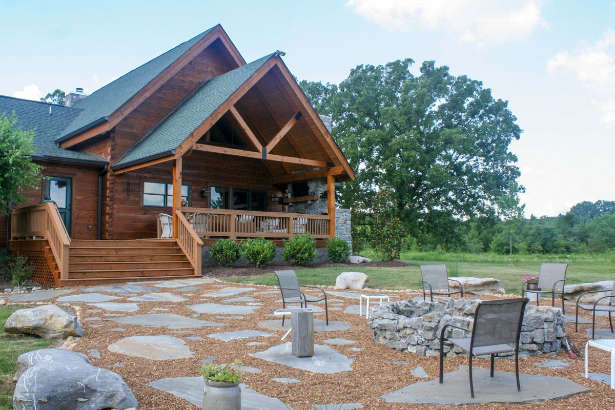 back stone patio behind log cabin