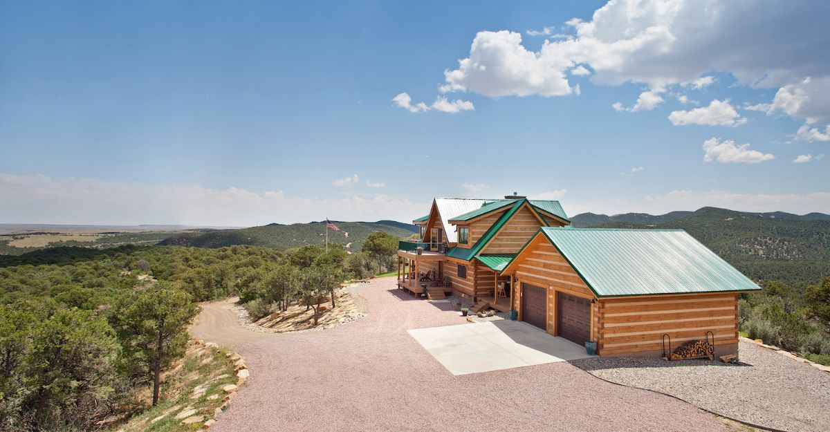 green roofs on light wood log cabin with blue sky background