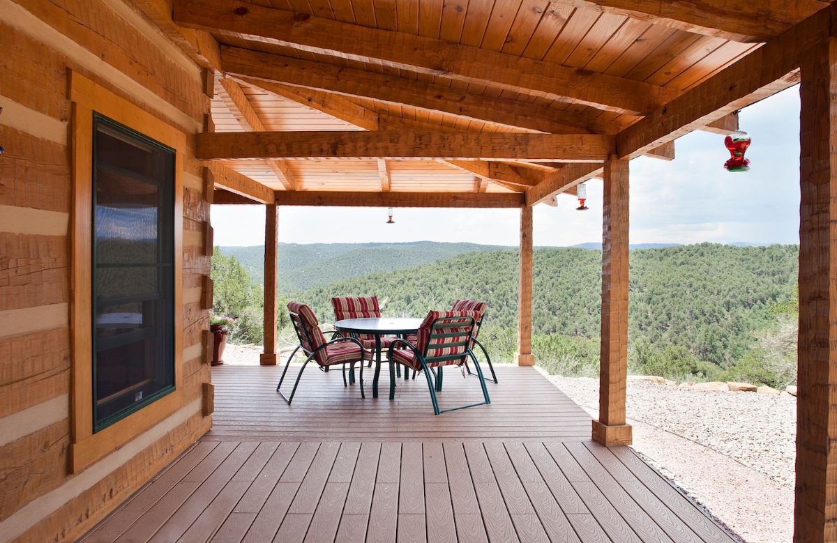 view down covered porch showing bistro set at end