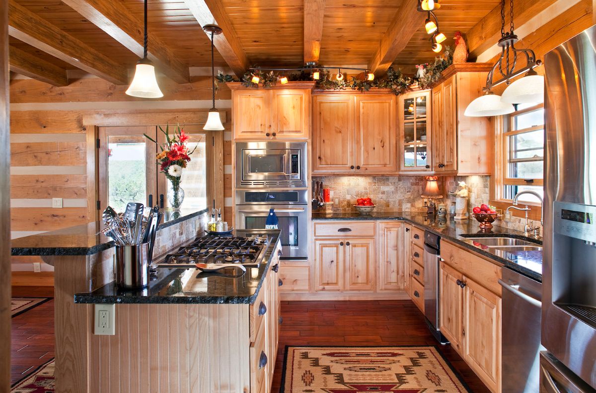 light wood cabinets with stainless steel appliances and dark granite countertops