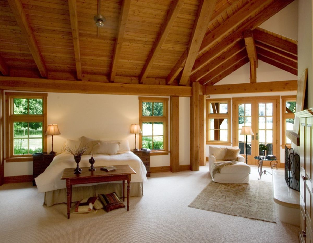 bedroom with white walls and wood ceiling and trim with reading nook on right