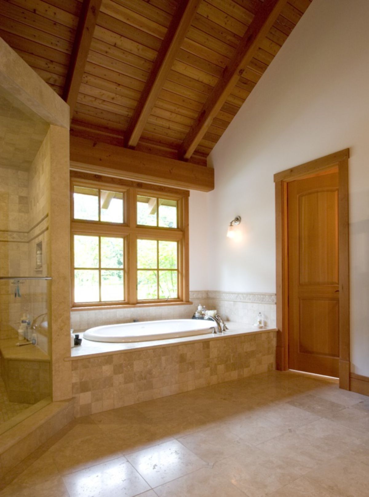 cream tile around white soaking tub with cream tiled shower on left