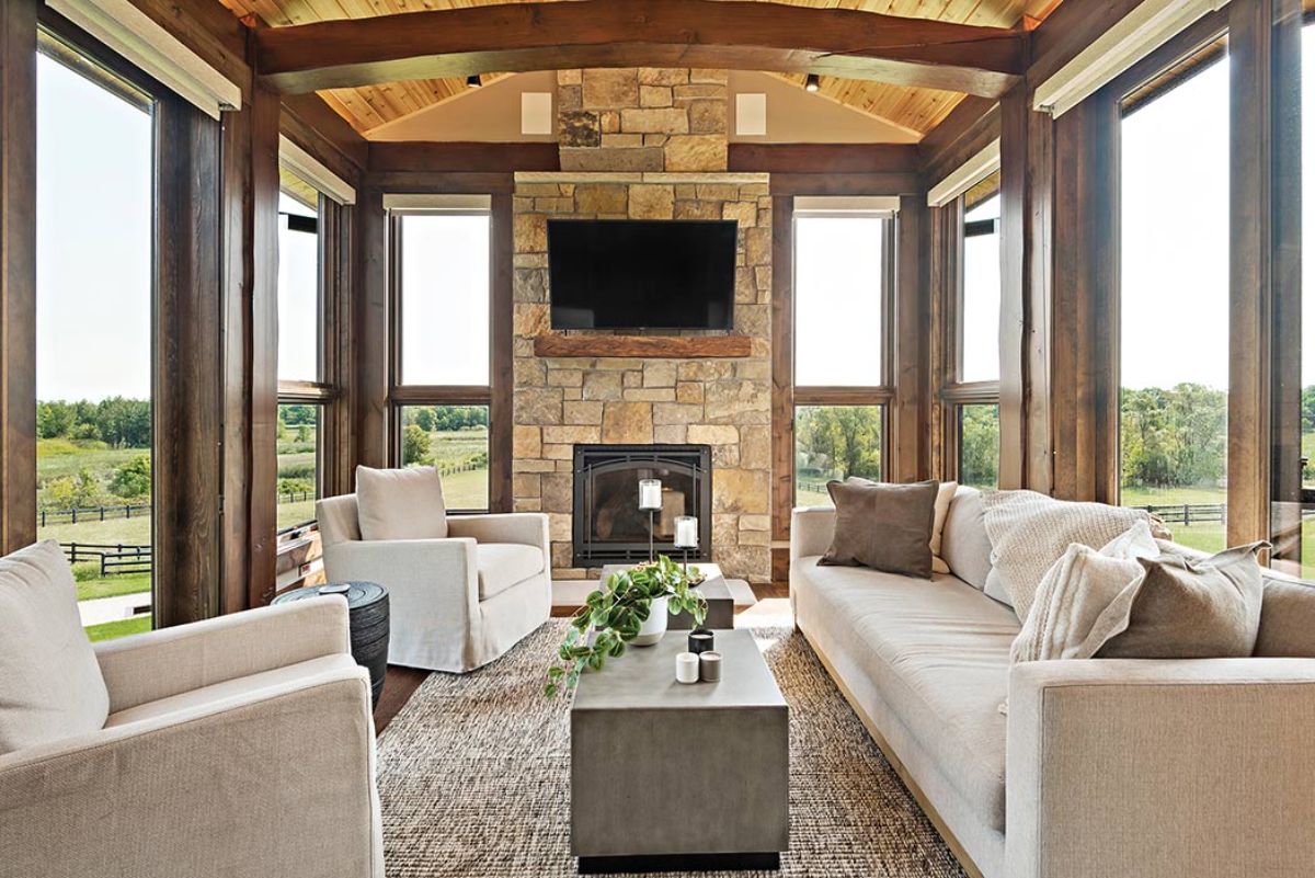 light cream sofas around gray coffee table with cream brick fireplace between windows