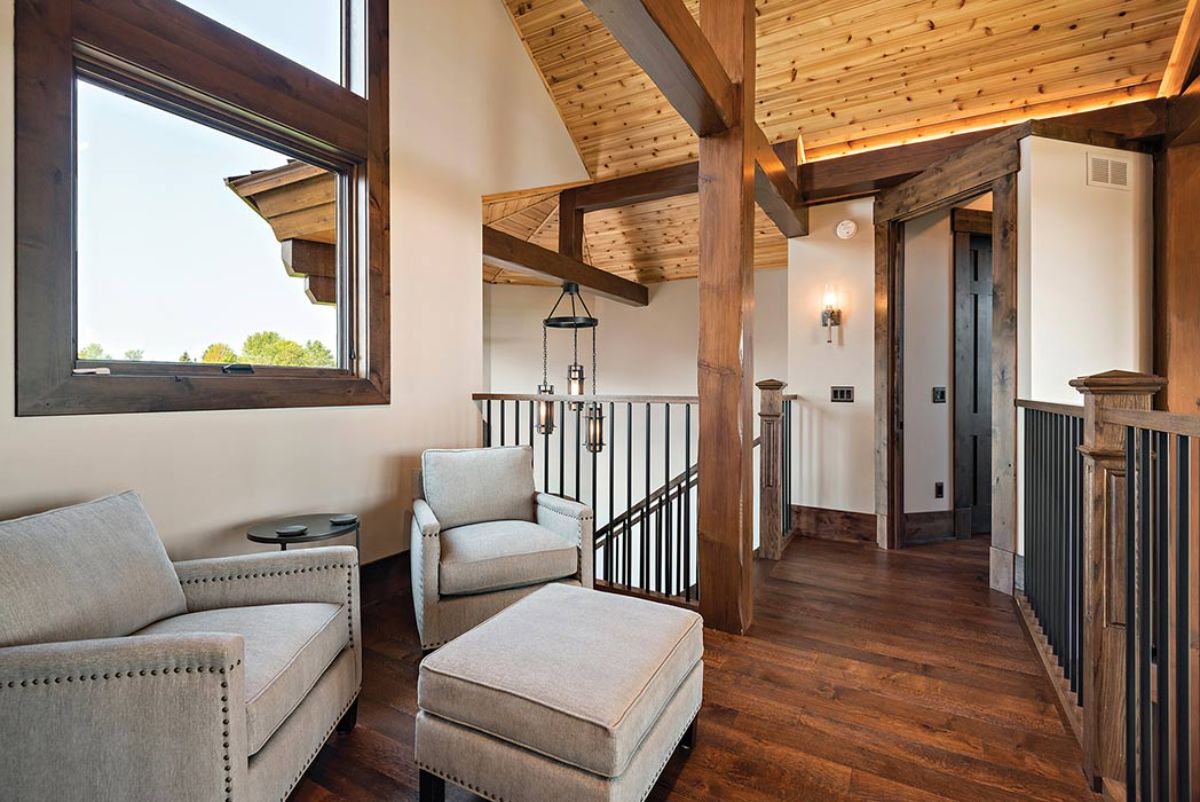 white sofa and ottoman under window in log cabin loft