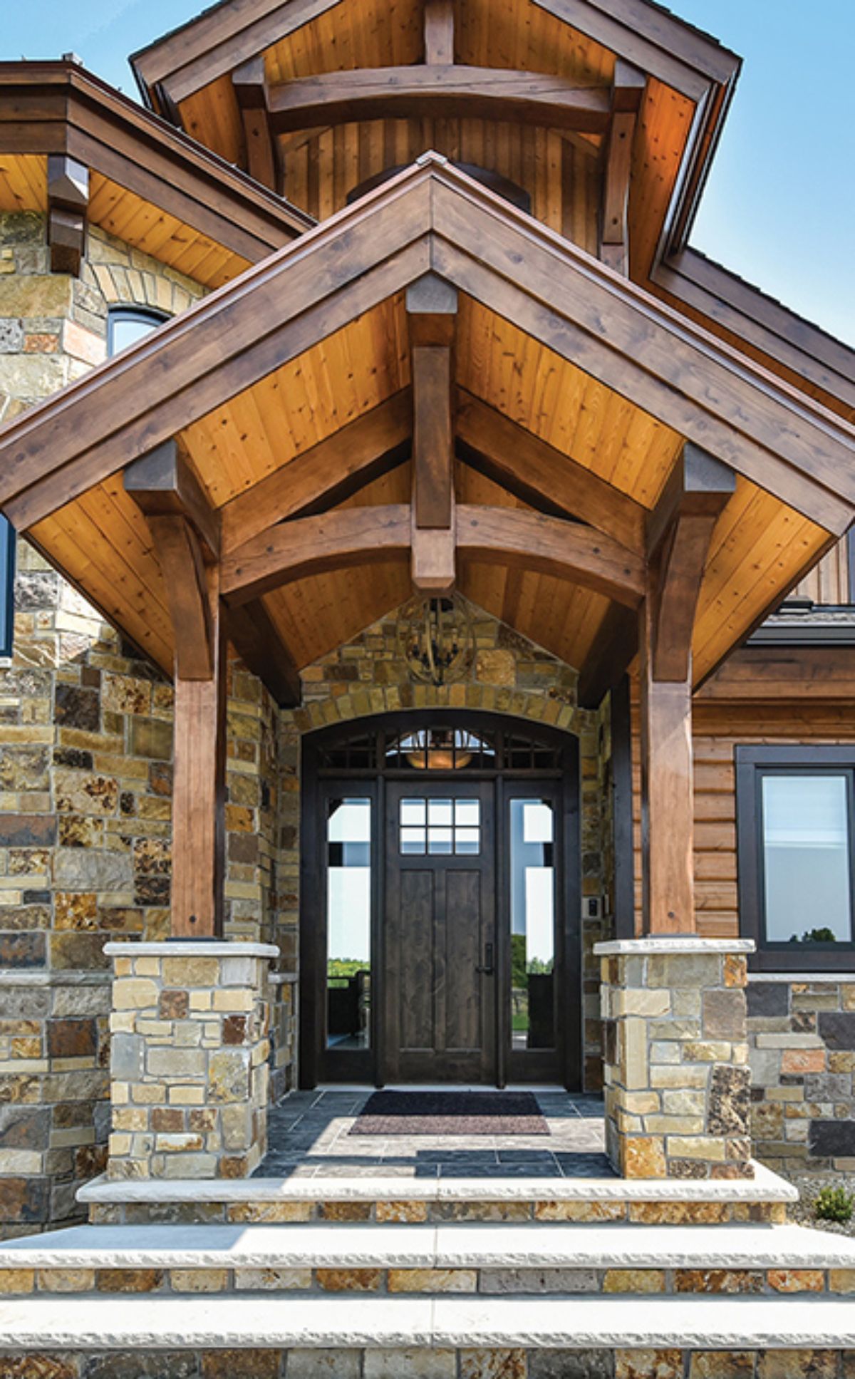 front door to cabin with stone columns and wall