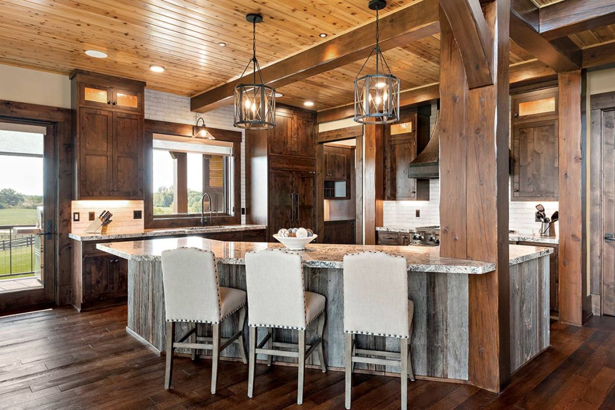 white high backed stools at bar leading into kitchen with dark wood cabinets