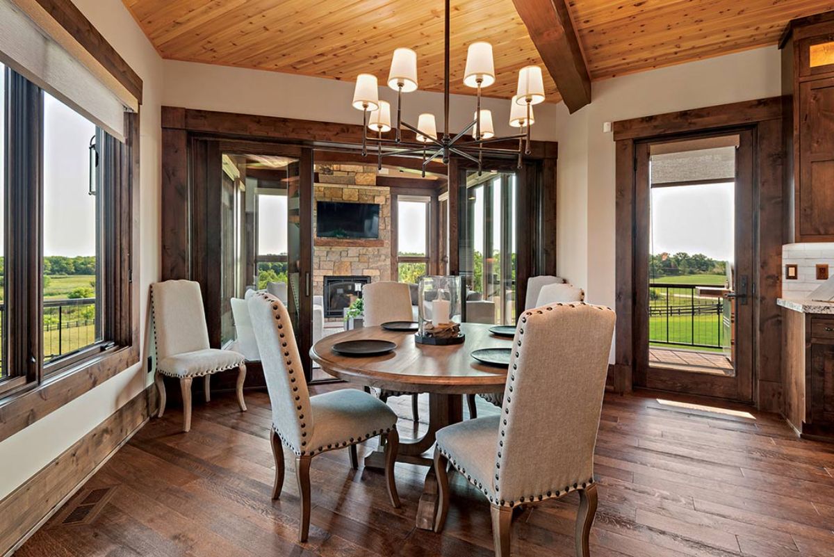 light cloth upholstery chairs around round table under chandelier