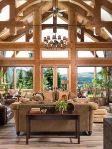 view across the back of brown sofa to the wall of windows overlooking mountains