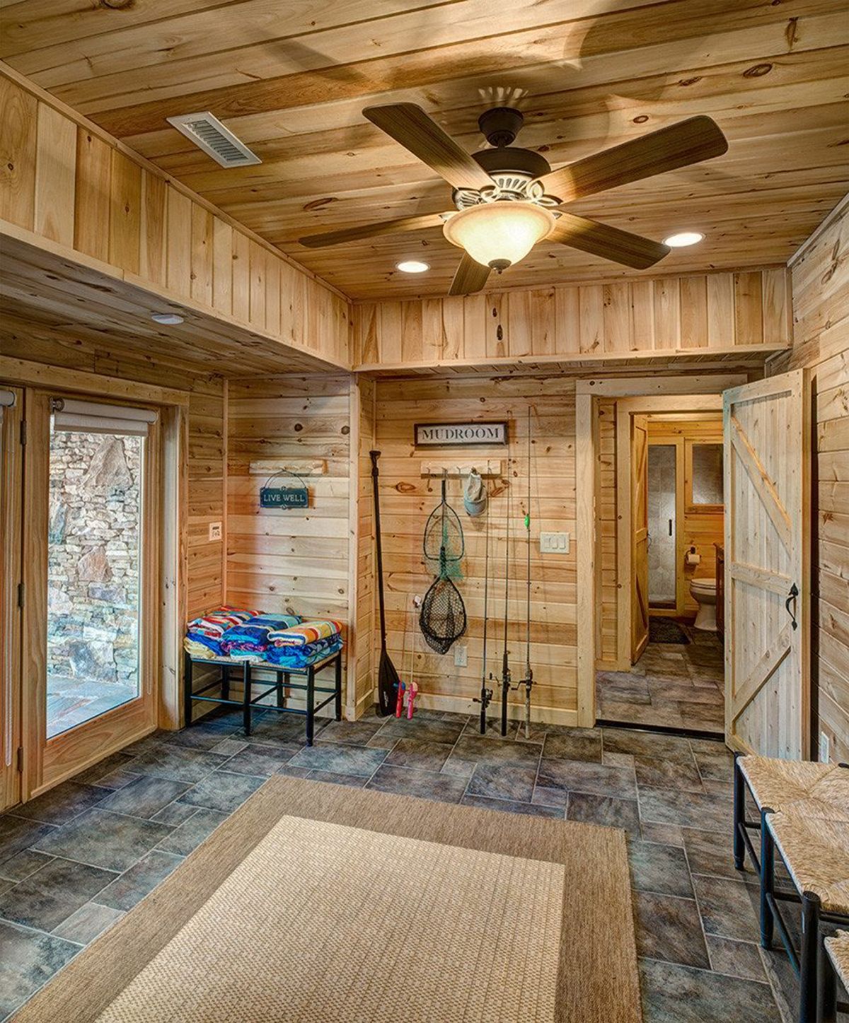 mud room with open door on back wall and bench on right side