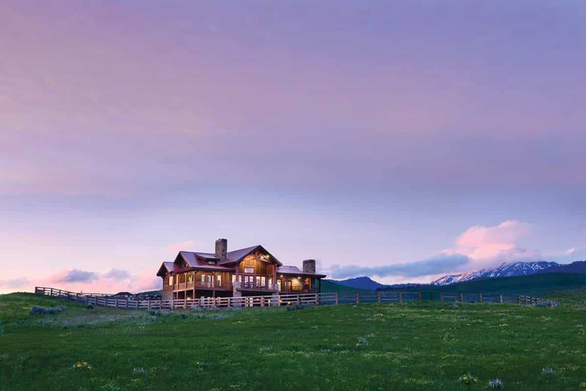 log cabin in field with sunset background