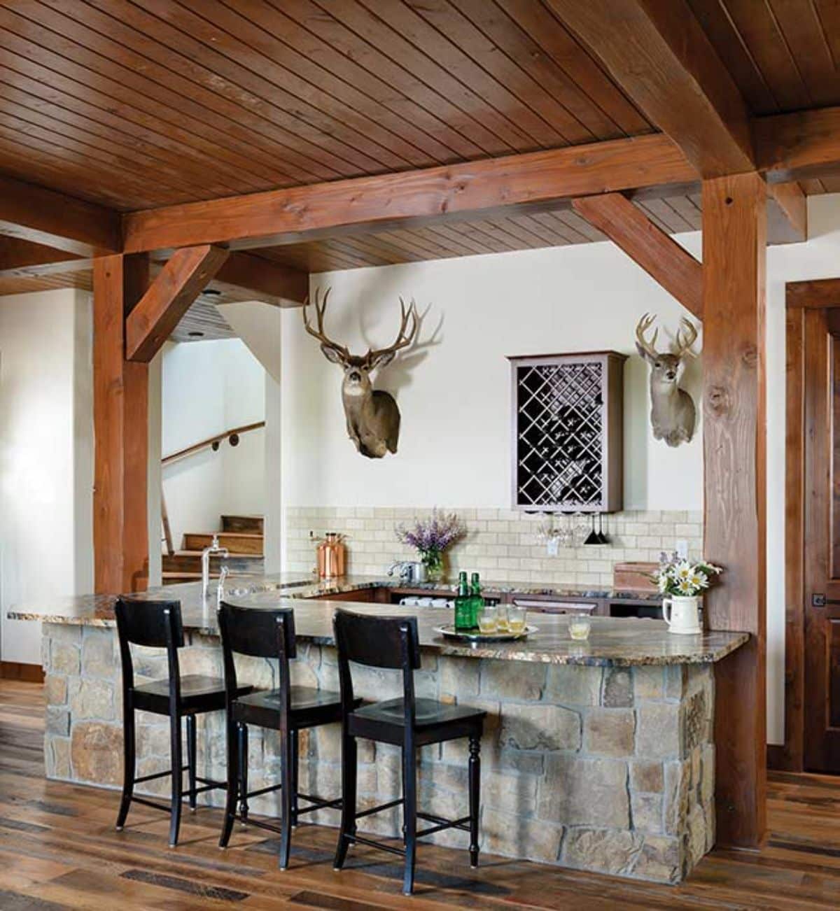 bar with distressed light wood outside and black high backed stools