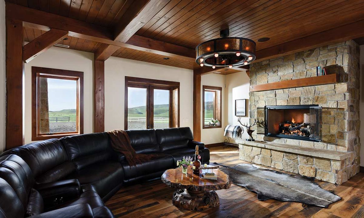 black leather sofa against wall on left with fireplace on right