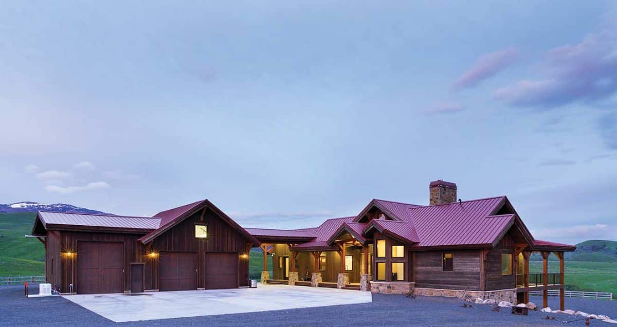 cabin with detached 2 car garage and black asphalt drive