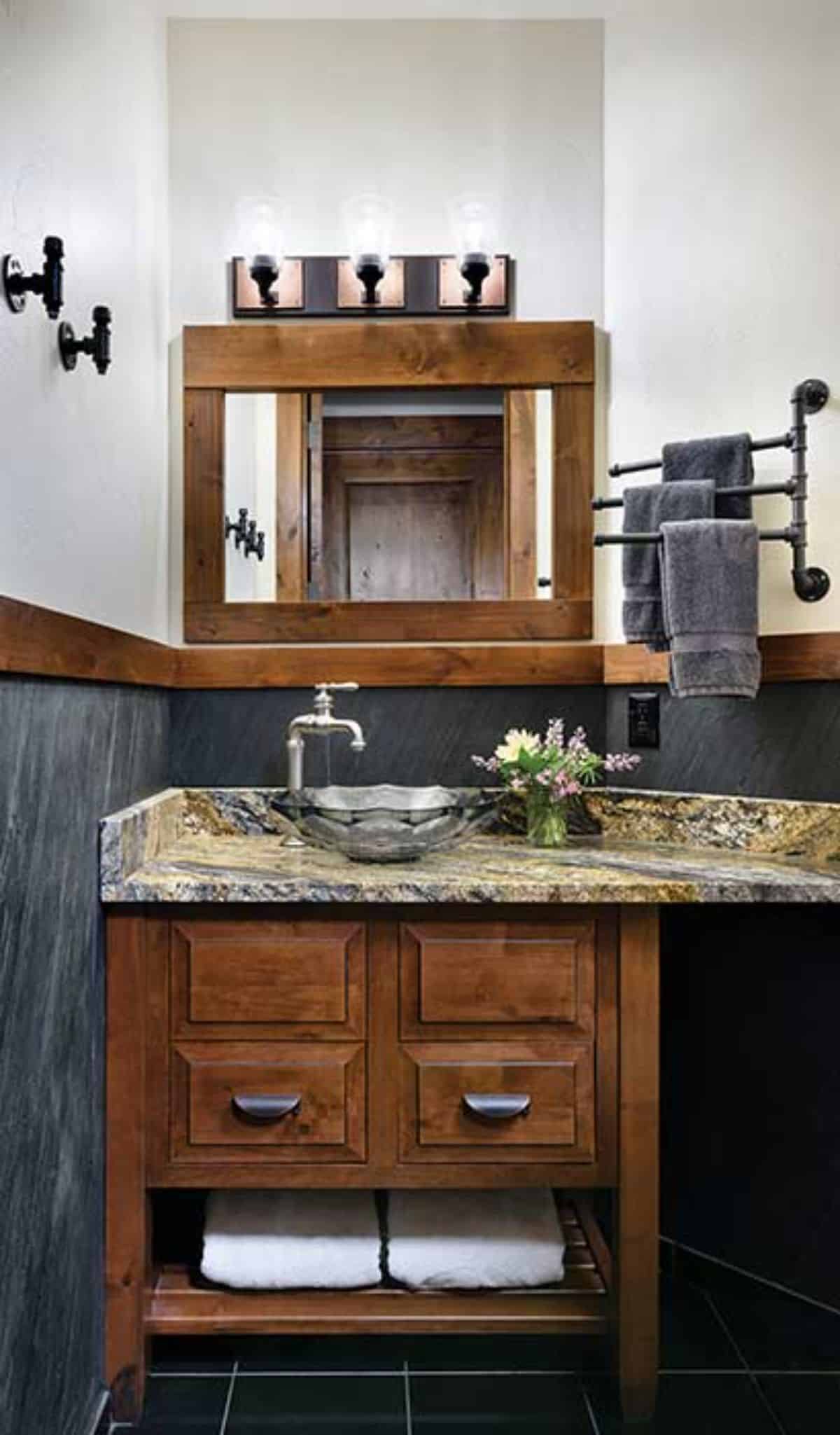 gray and white walls in bathroom with light wood cabinets and mirror