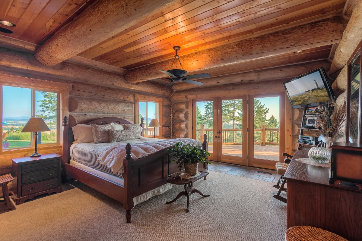 bed against wall with french doors on right wall leading to deck