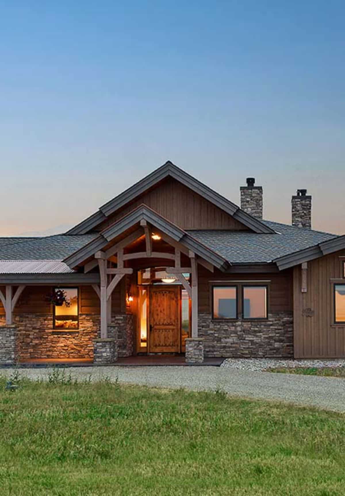 front door of cabin covered with stone surround and wood siding