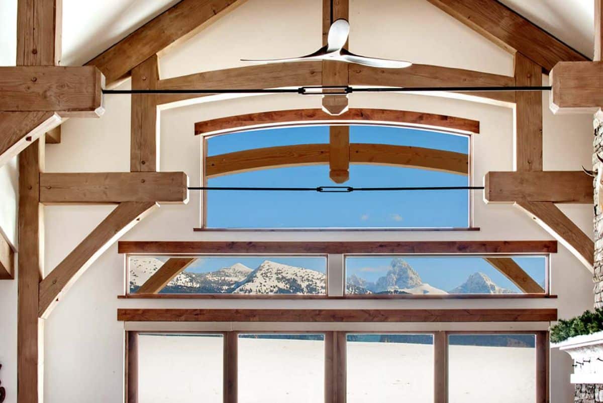 view across top of cabin great room with white walls and exposed wood beams