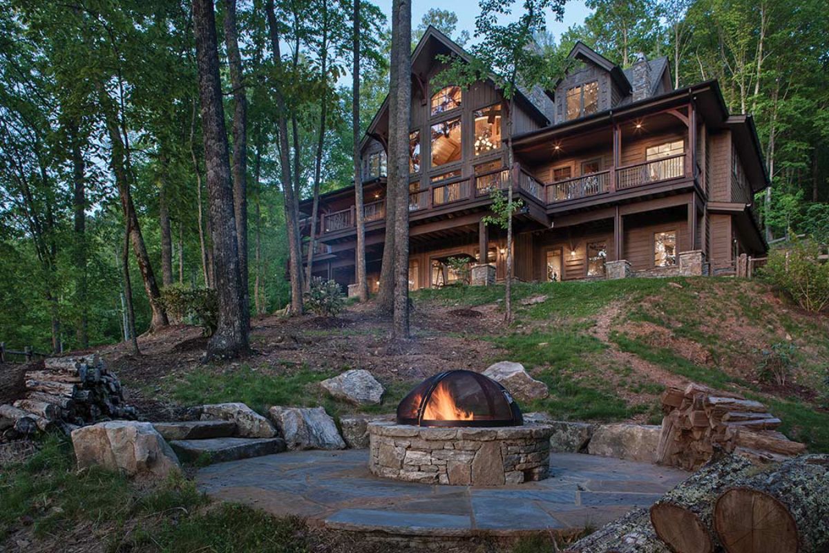 dark wood cabin in background with firepit in foreground