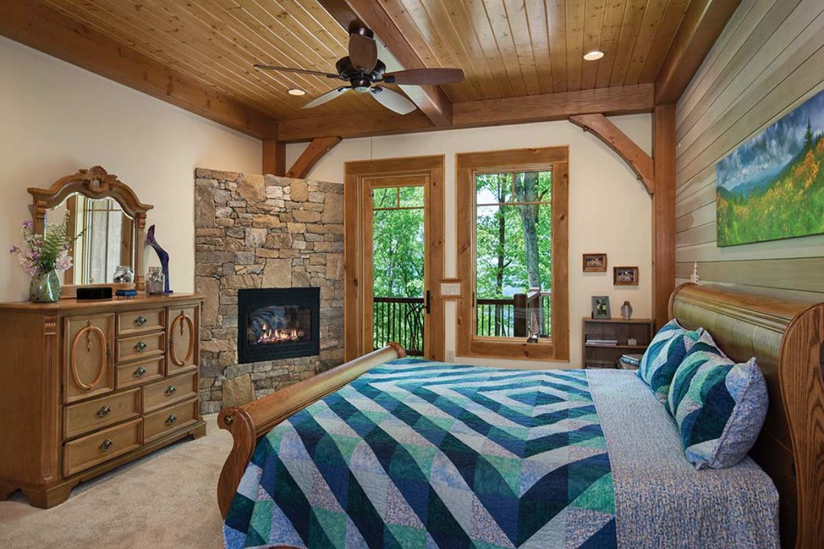 blue and white striped bedding on bed in master bedroom with fireplace onl eft