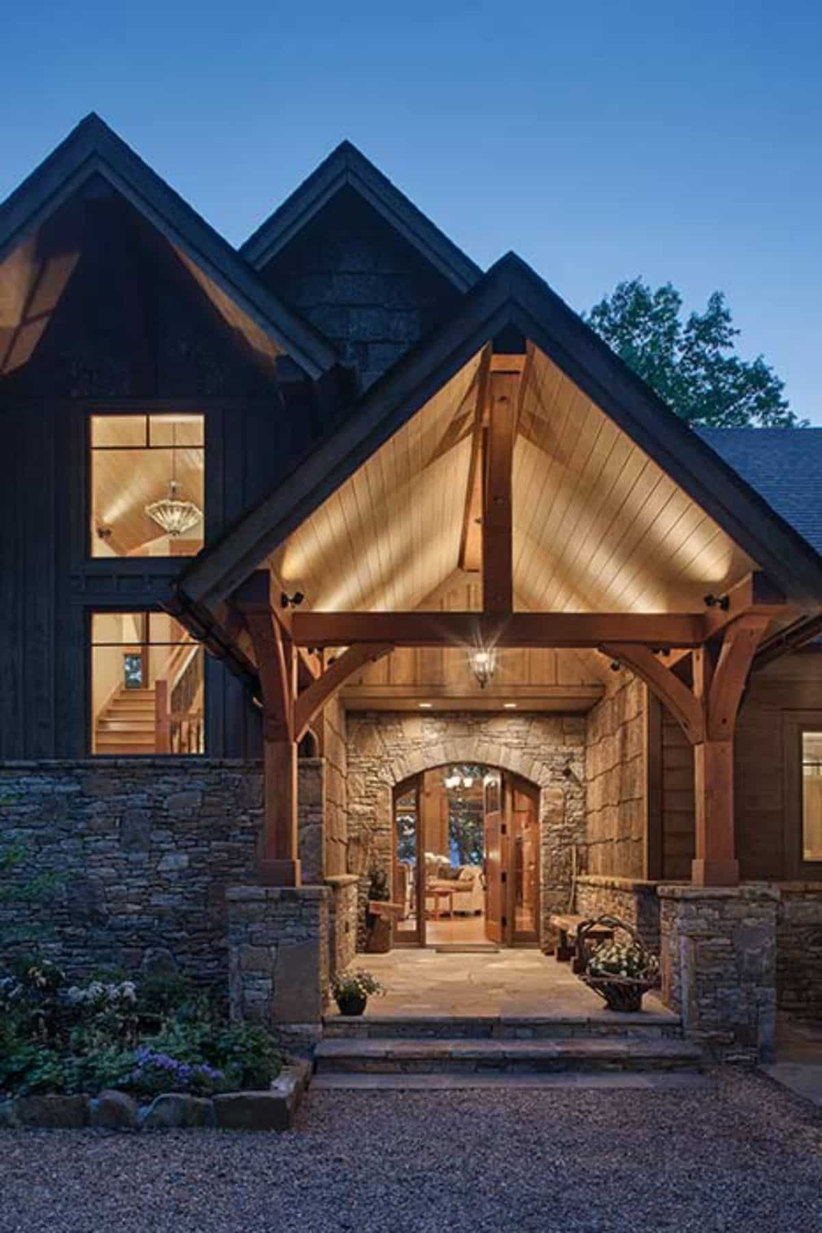 front porch over door lit up with lights above in archway and stone columns