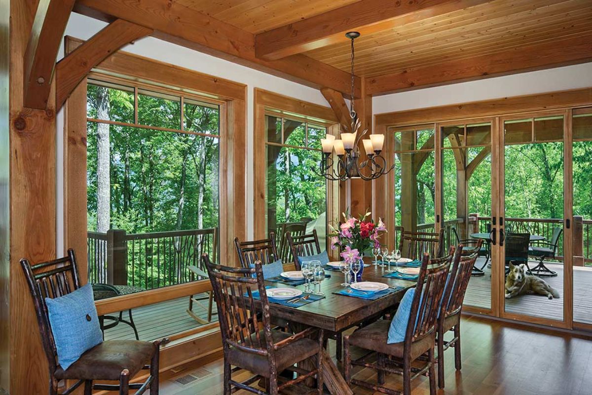 metal back chairs around dining table with wall of windows to left