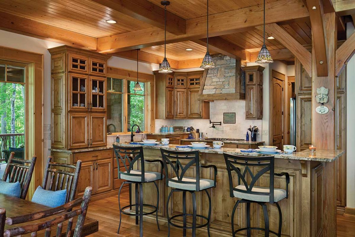 high back stools in front of island in kitchen with white walls