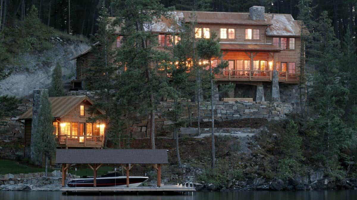 cabin on hill above dock with rock wall between river and home