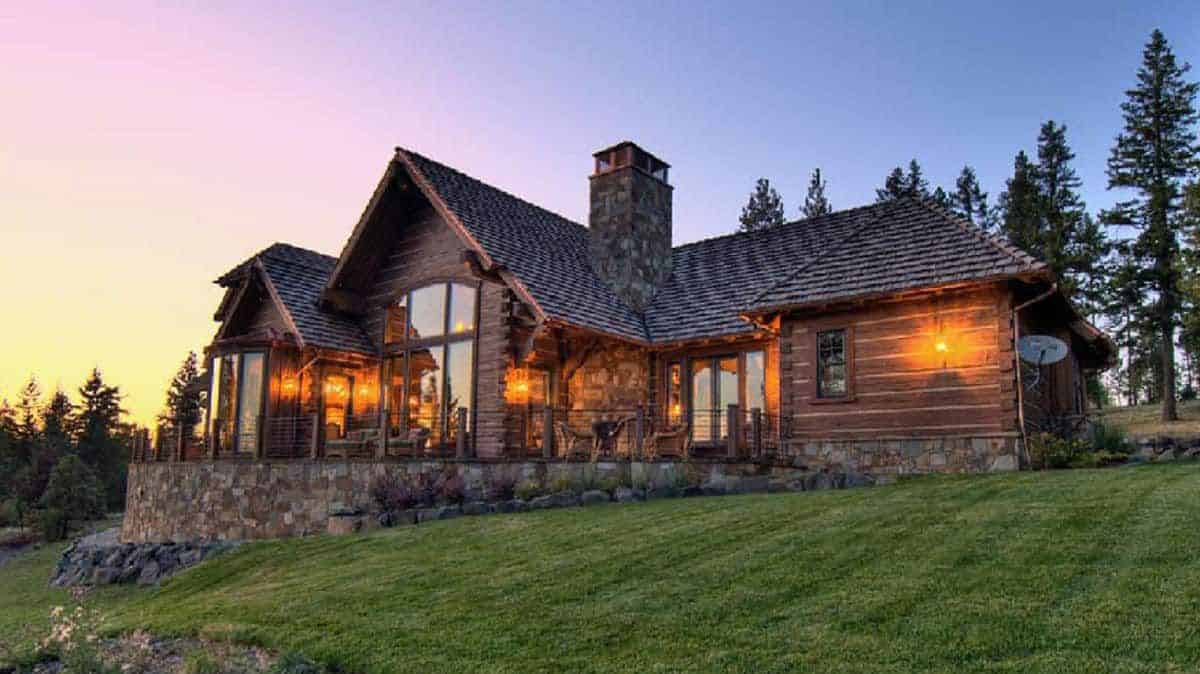 front of log cabin with stone accent exterior and chimney on right