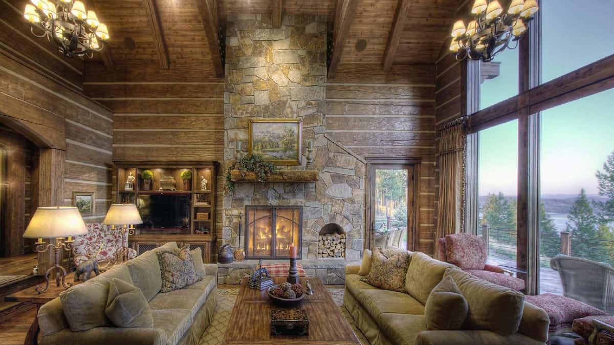 stone fireplace and chimney against back wall with light brown sofas on both sides