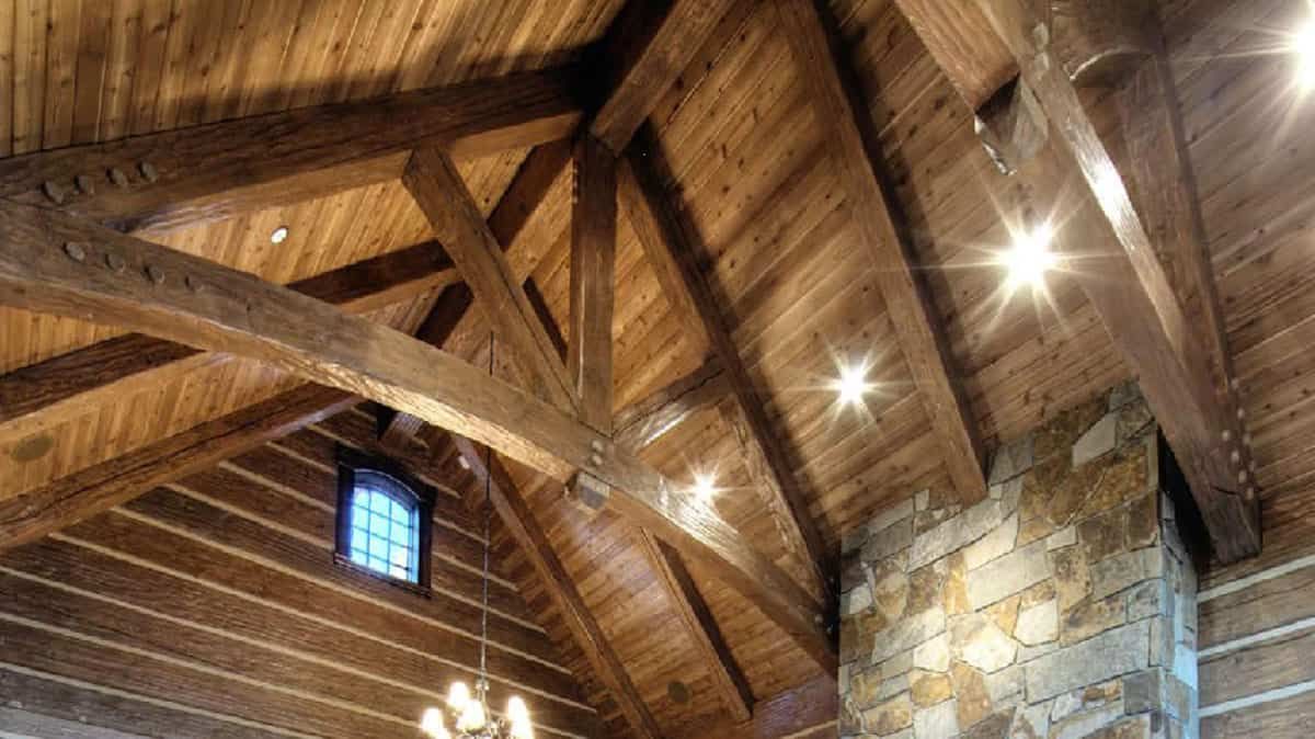 view looking up at exposed beam ceiling inside cabin living rea