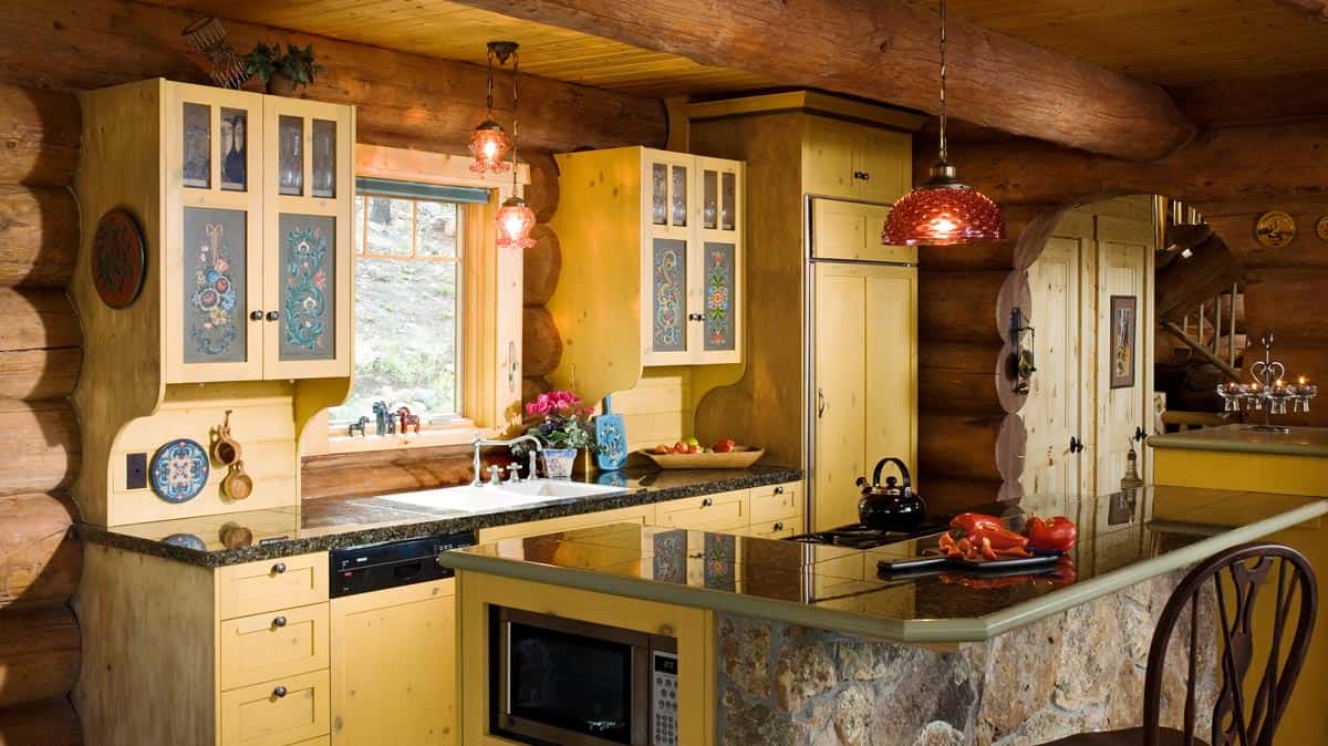 yellow cabinets in kitchen with island that has stone exterior
