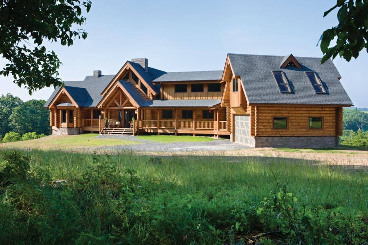 log cabin with light wood stain siding and garage on end