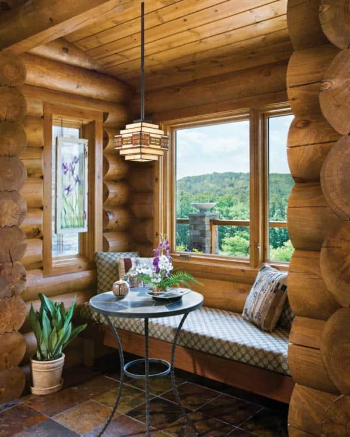 bench seat with cushions and small round table in front of window seat