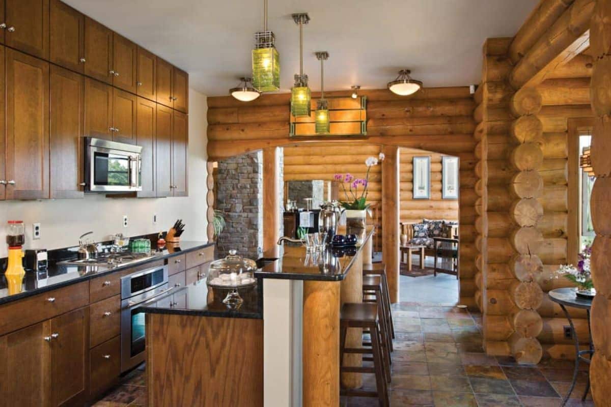 kitchen with wood cabinets and white walls with a bar on outside of kitchen island