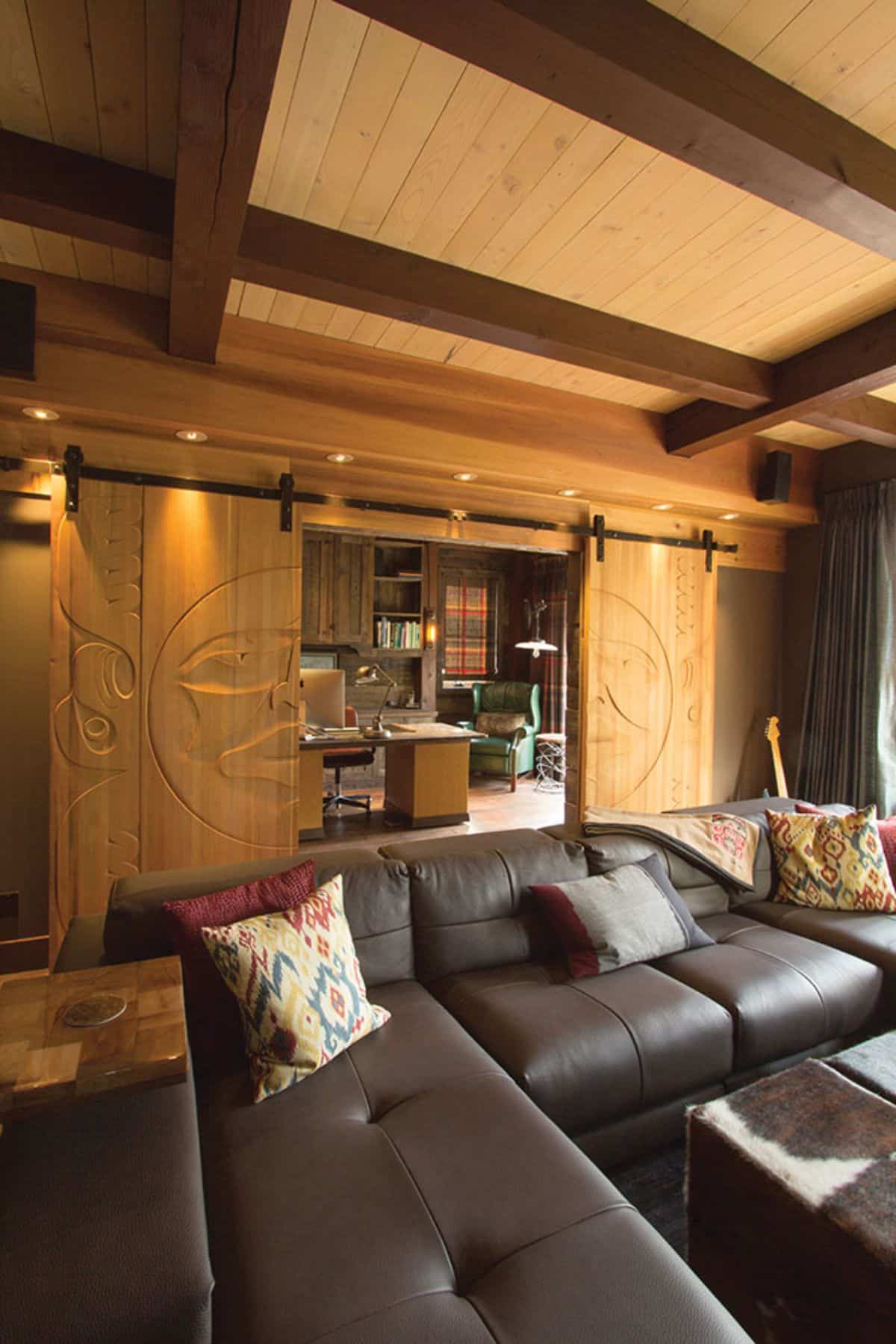 brown leather sofa in front of sliding barn doors leadign into home office