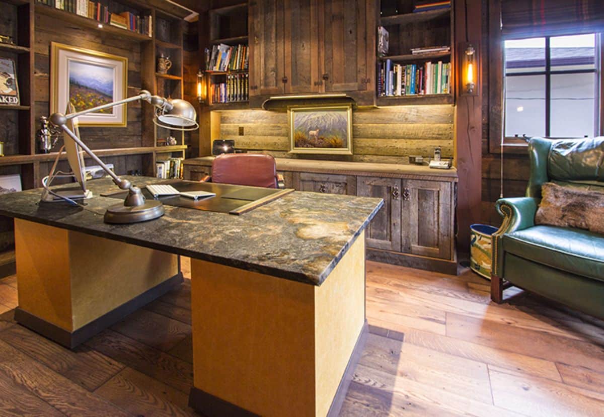 light wood desk with granite top and dark wood cabinets in background