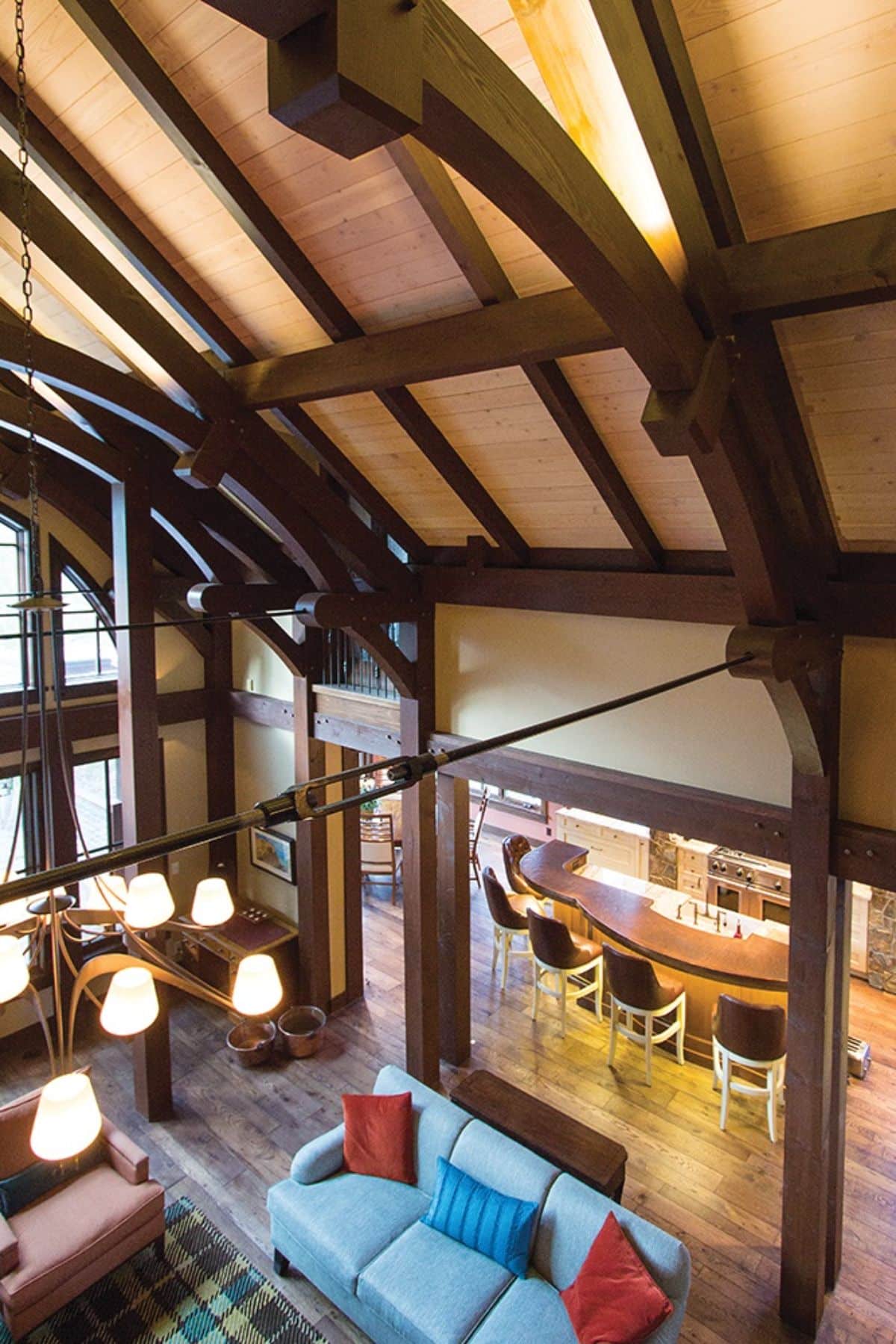 view into living space with bar in right background from loft showing exposed beams