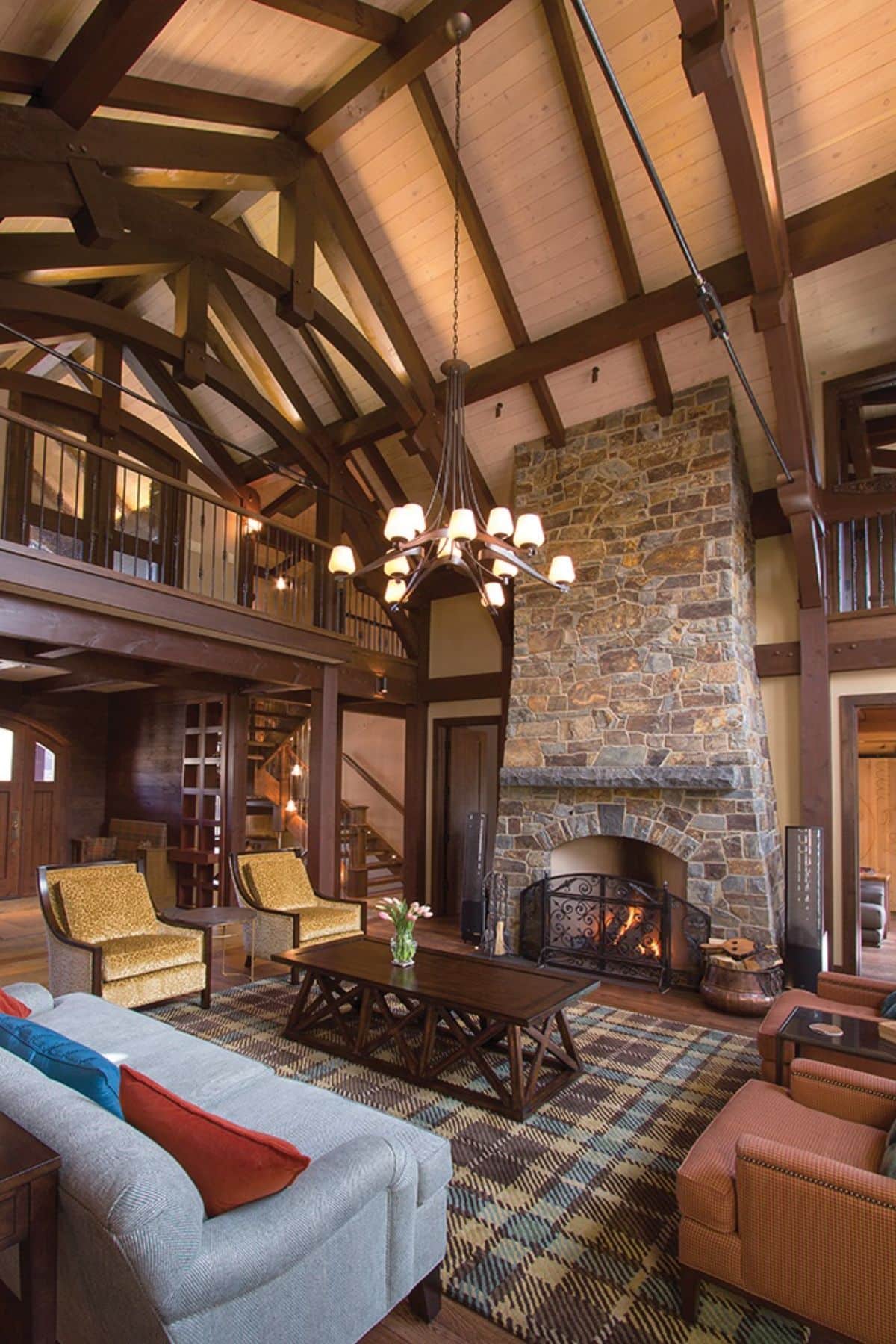 stone fireplace on right wall of living room with wood table and yellow chairs on left