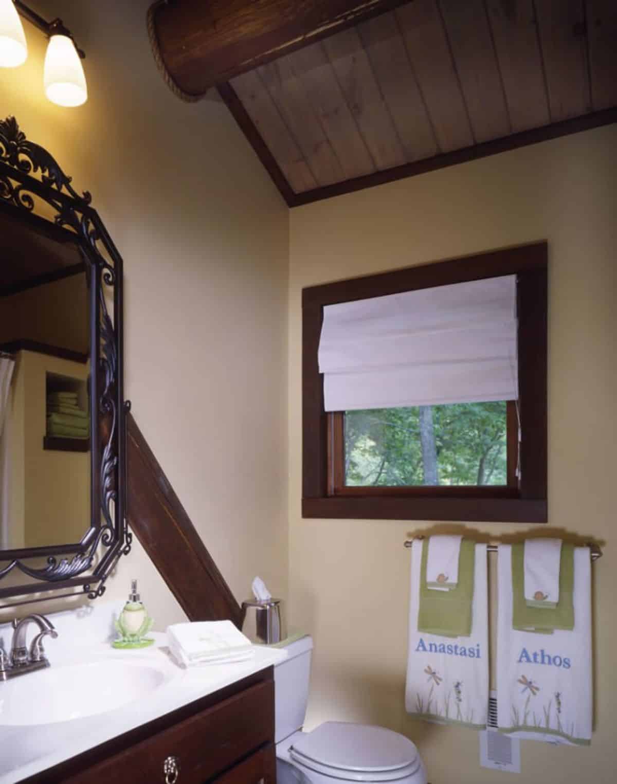 view into bathroom with mirror on wall to left above white sink