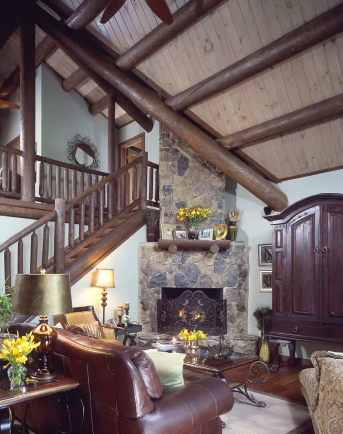 stone fireplace in corner of living room featuring dark wood stain