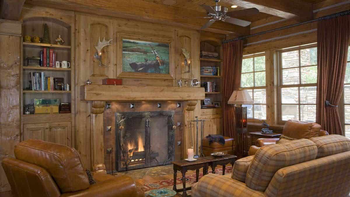 fireplace with wood mantle on left wall with chair and sofa on right side