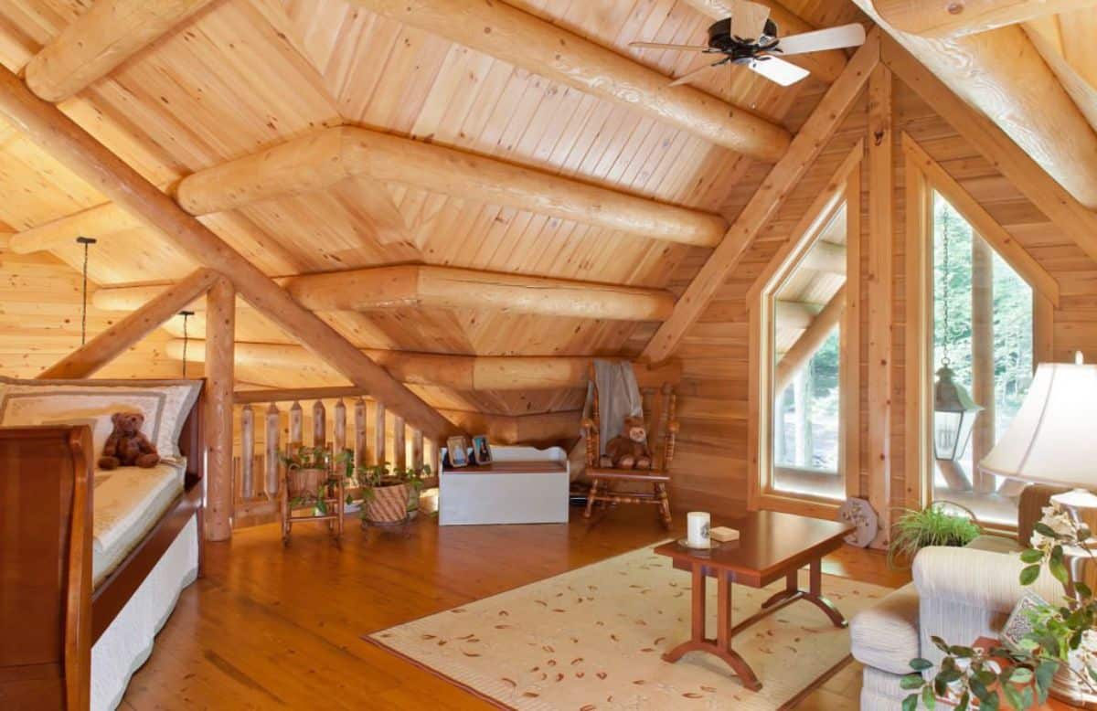 open loft space with small table on right and rocking chair against far wall