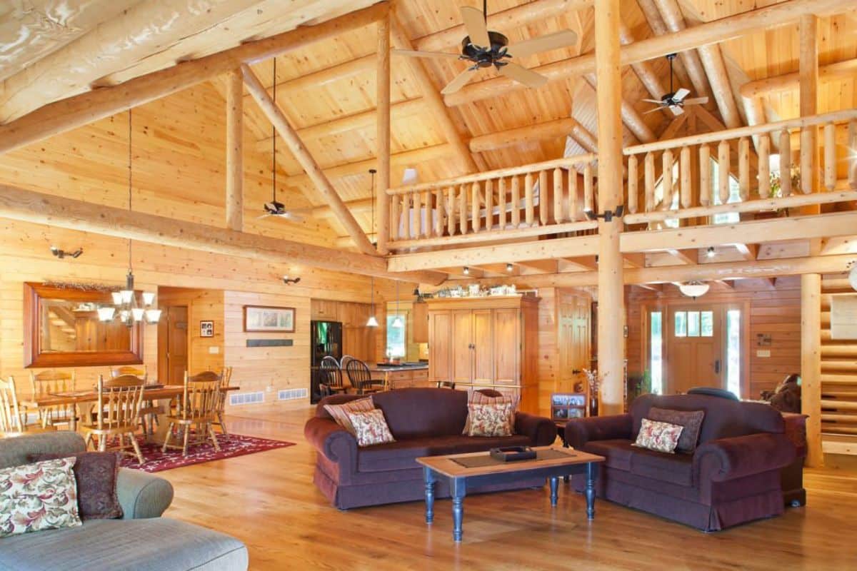 dark brown sofas underneath loft railing inside cabin living room