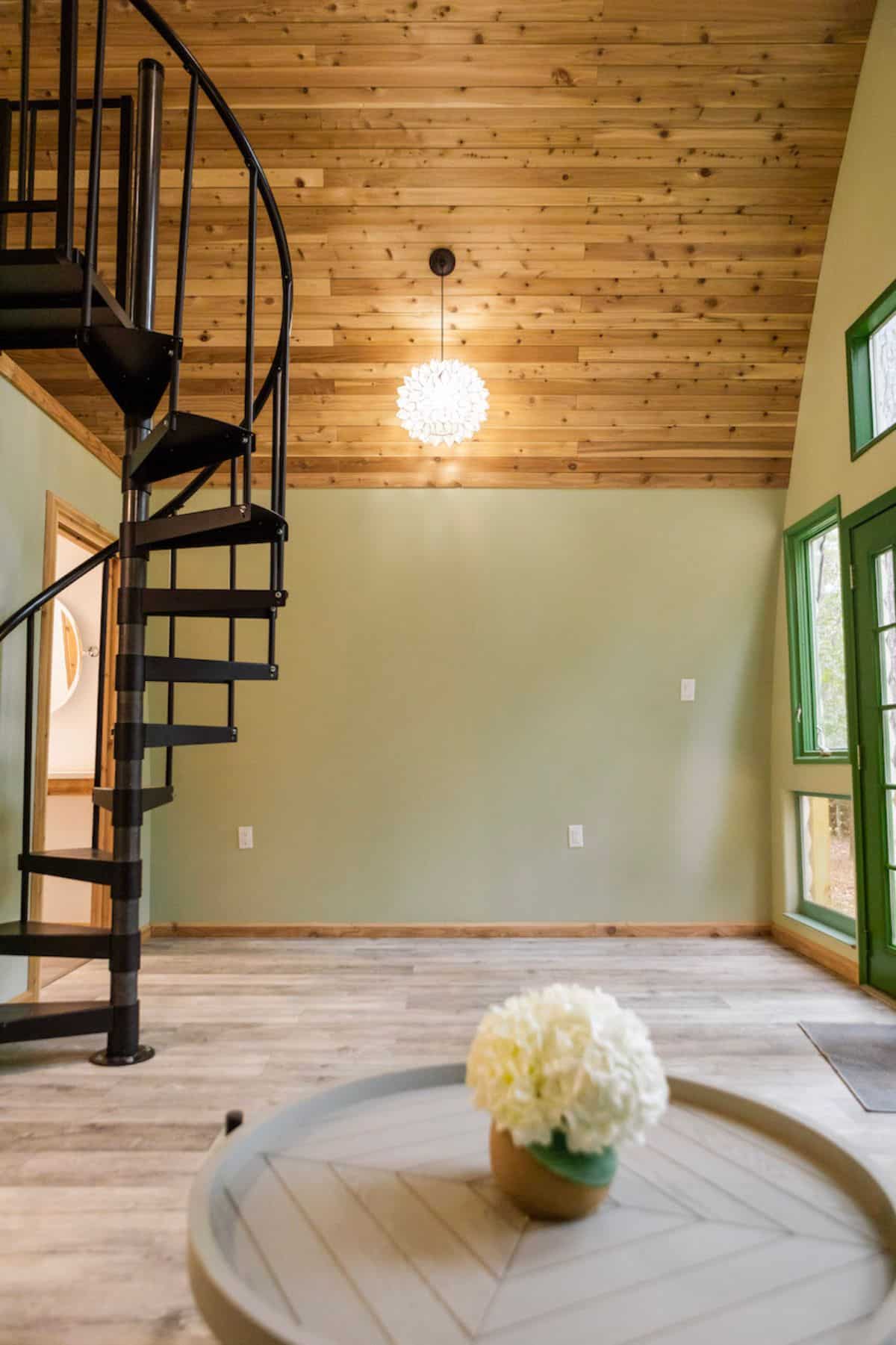 light green wall with stairs on left and windows on right