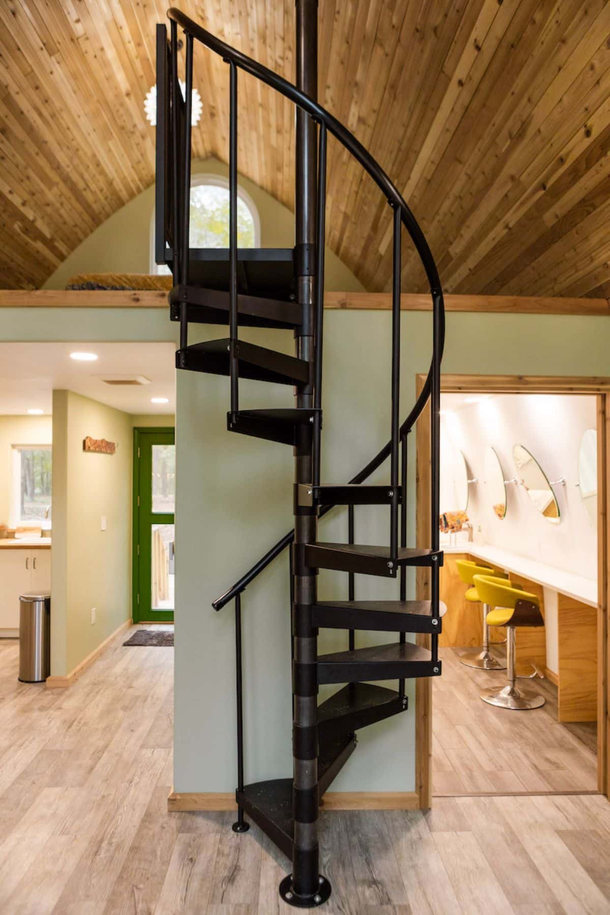 black spiral staircase leading to loft in center of home