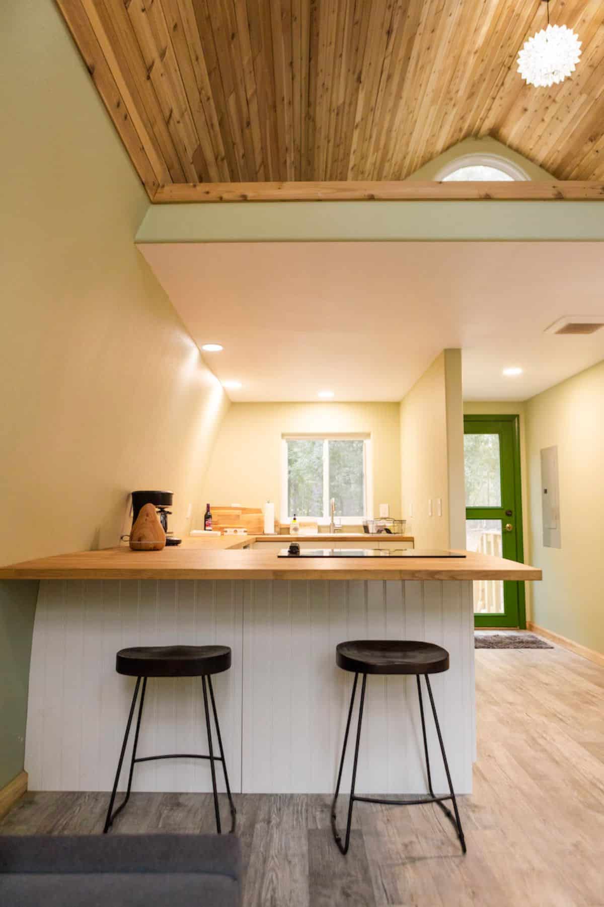 two black stools against white and butcher block bar of kitchen
