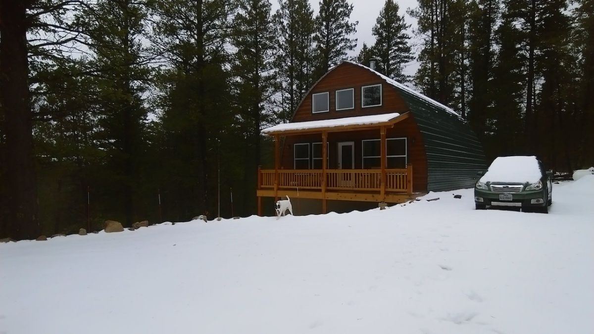 cabin on hill with snow in yard