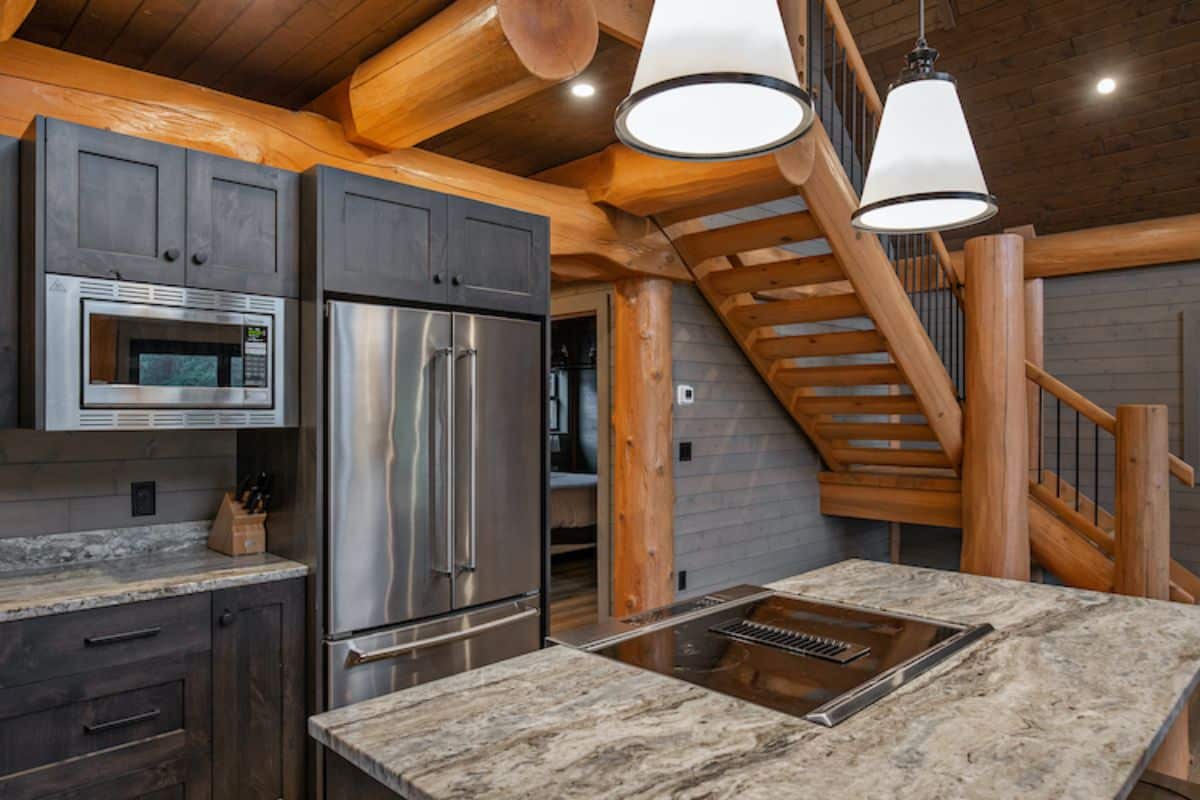 stainless steel refrigerator and microwave in gray wood cabinets