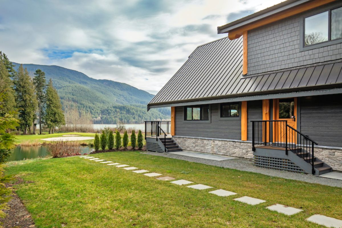 side of gray cabin with rock path